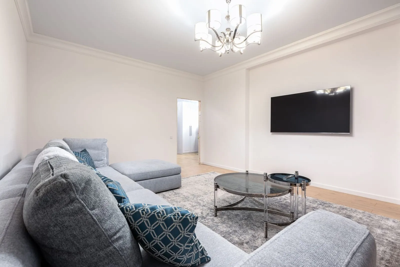 Séjour clair avec canapé et grande hauteur sous plafond