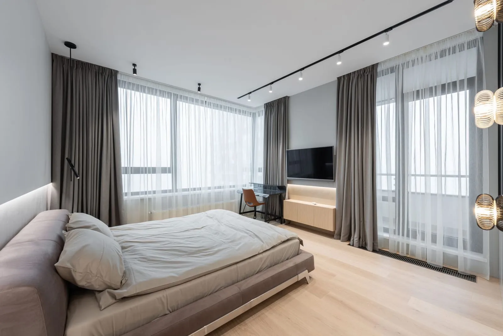 Chambre lumineuse avec rideaux et grande fenêtre
