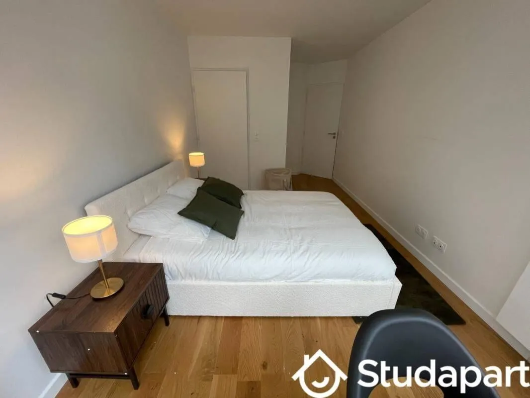 Chambre meublée avec lit double, table de chevet et fauteuil