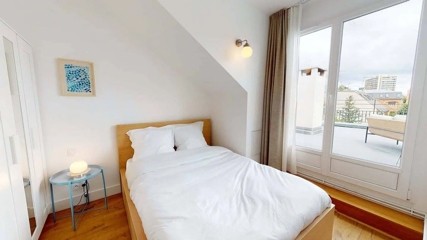 Chambre mansardée avec vue sur les toits