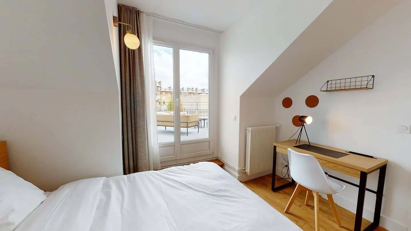 Chambre avec bureau et fenêtre de toit