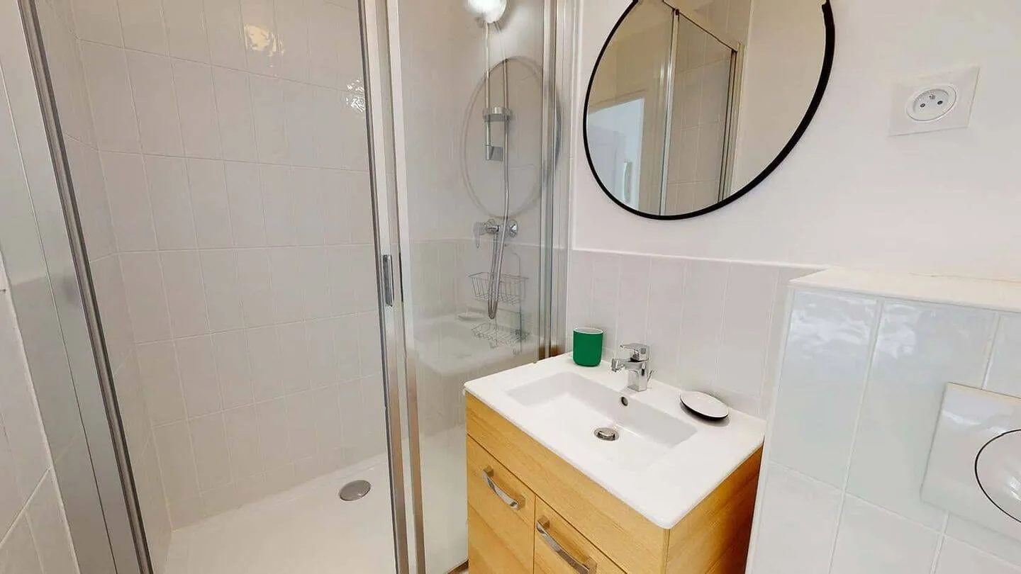 Salle d'eau privative avec vasque et miroir rond