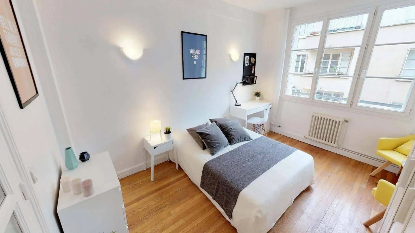 Chambre avec lit double et radiateur sous la fenêtre