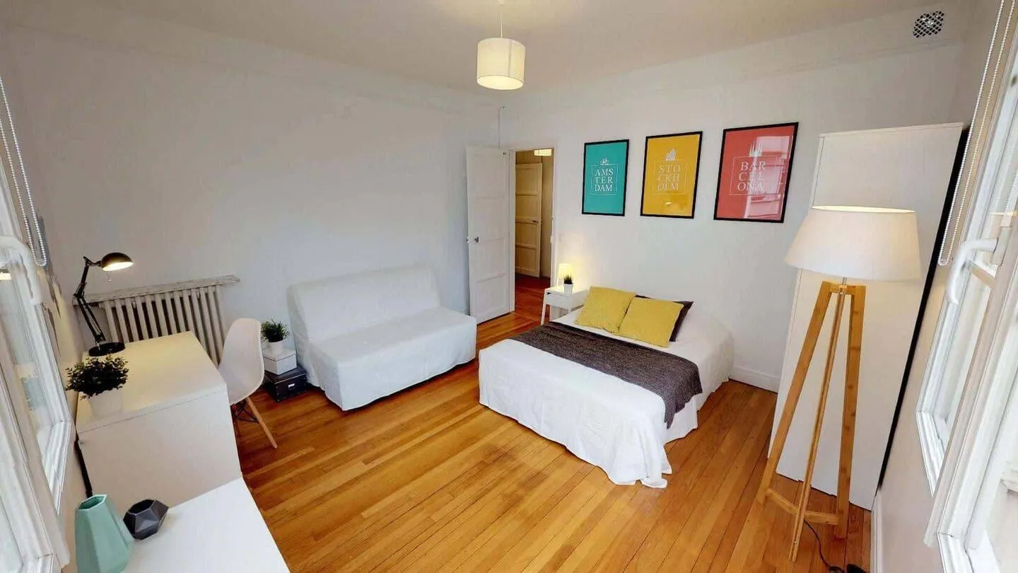 Chambre meublée avec lit et affiches colorées