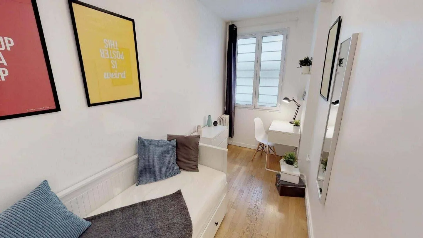 Chambre avec bureau devant la fenêtre
