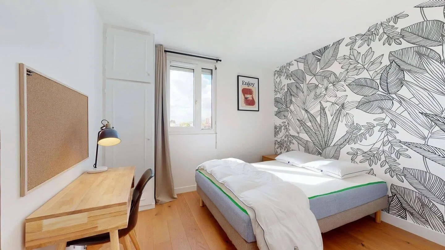 Chambre avec bureau devant la fenêtre