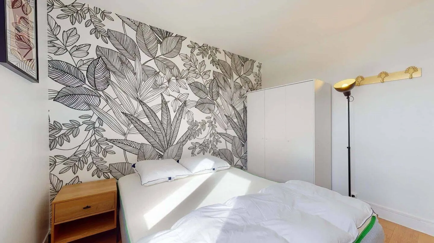 Chambre avec papier peint végétal et cadre