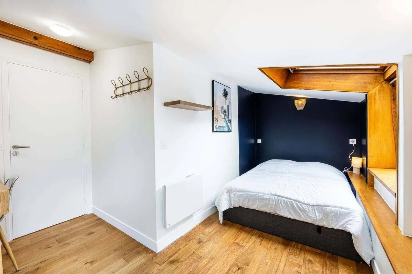 Chambre avec lit double et tête de lit en bois