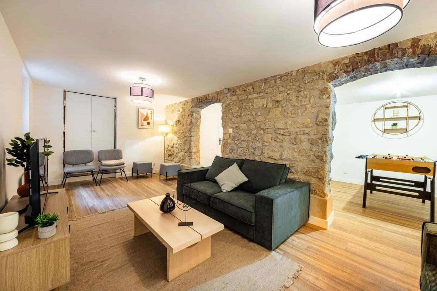 Séjour avec canapé et mur en pierre apparente