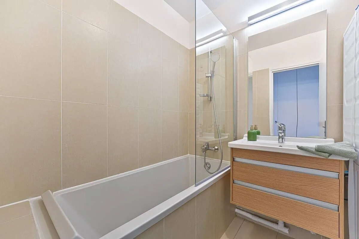 Salle d'eau avec baignoire et rangements
