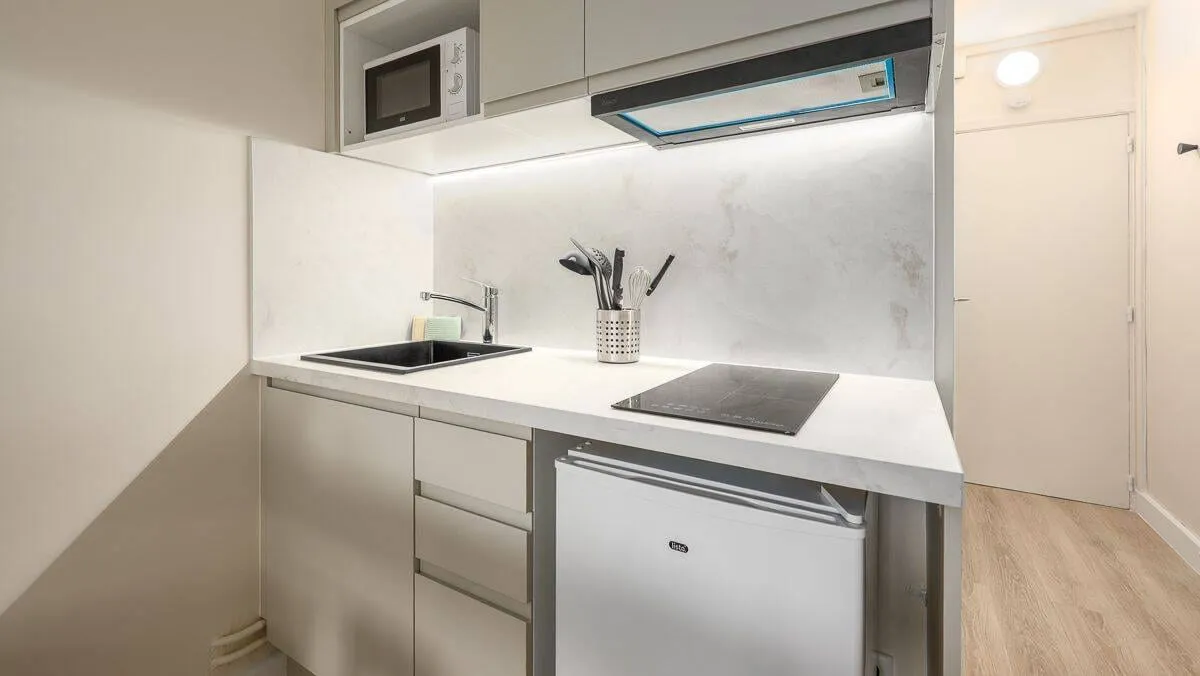 Kitchenette avec plaques et réfrigérateur