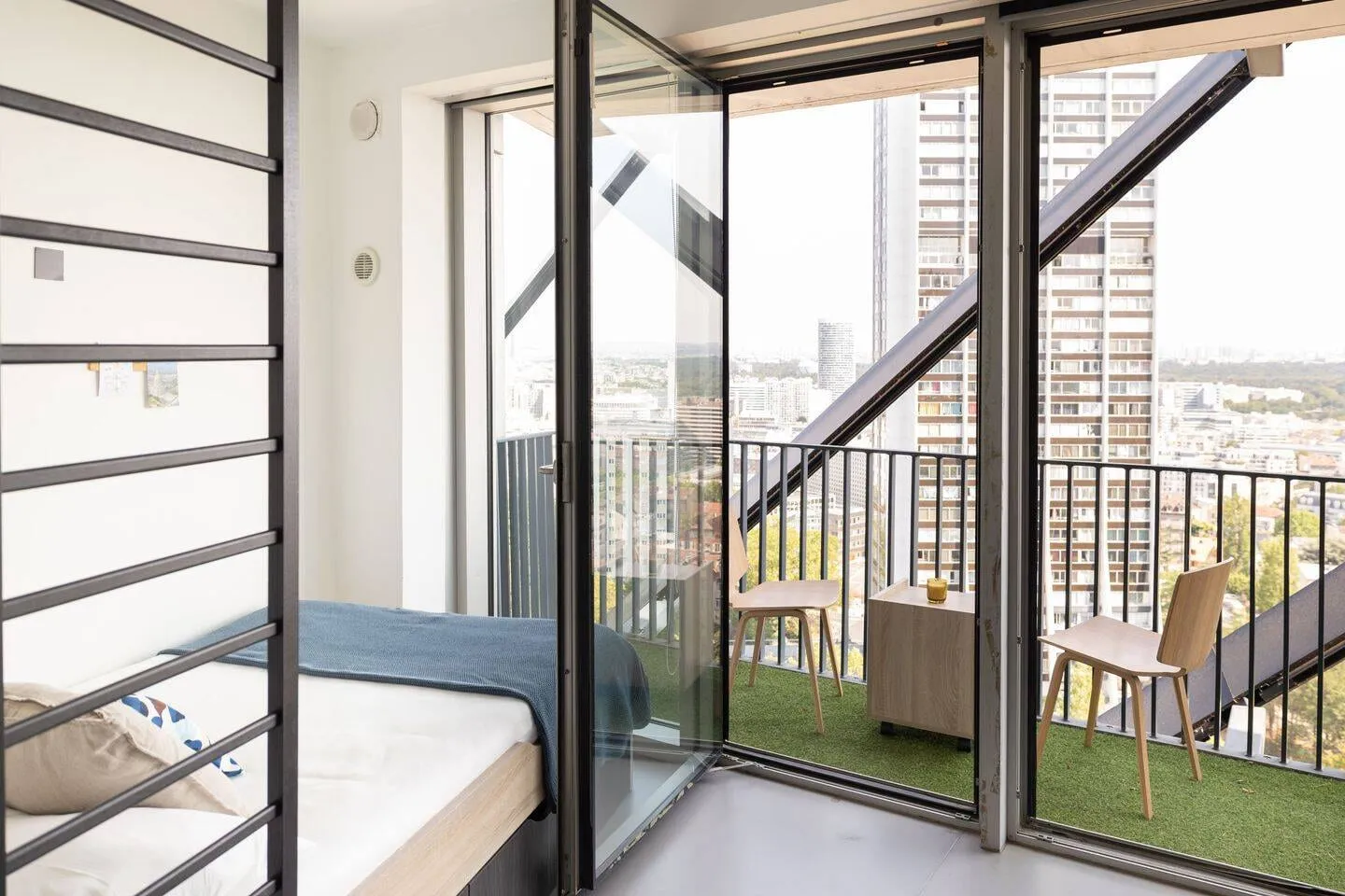 Studio avec grande baie vitrée ouvrant sur le balcon