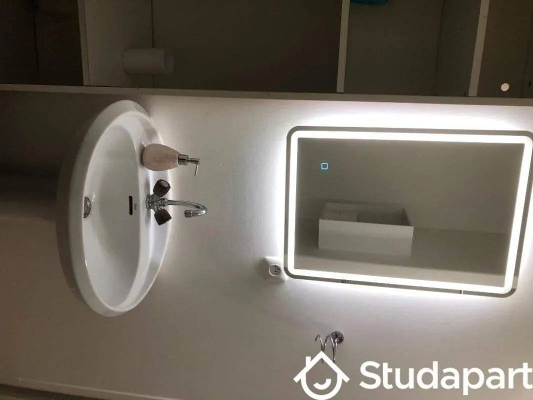 Salle d'eau avec vasque et miroir lumineux