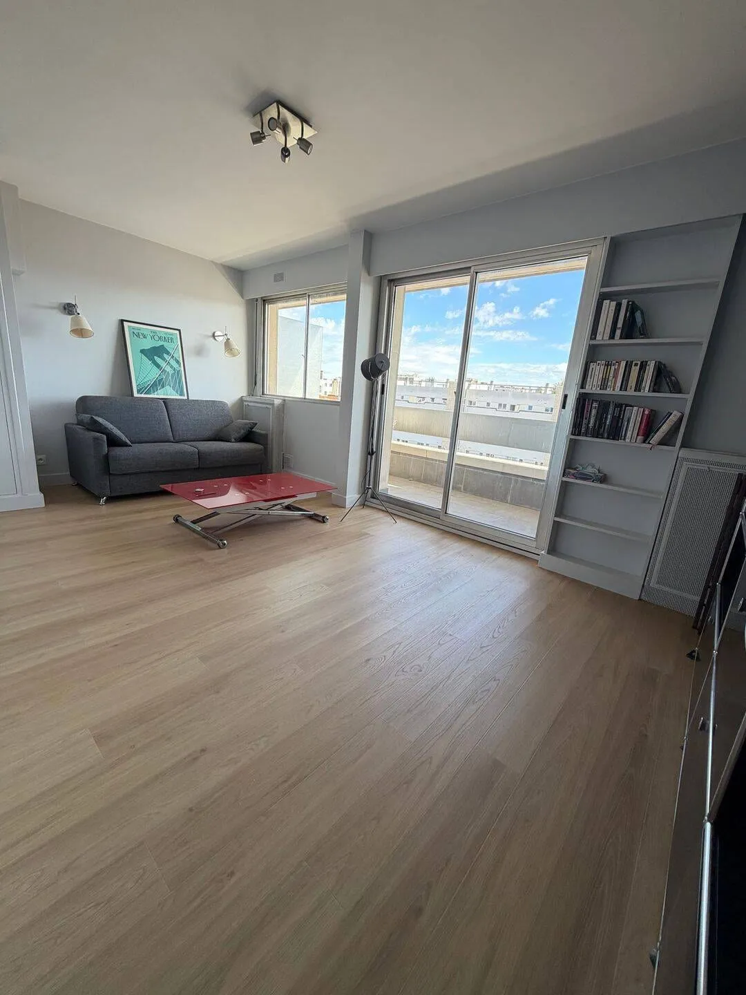 Séjour avec canapé et baie vitrée sur le balcon