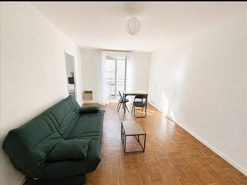 Séjour avec canapé vert et table
