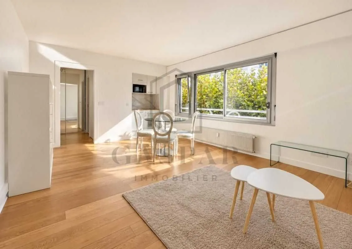 Pièce de vie avec parquet et grande fenêtre