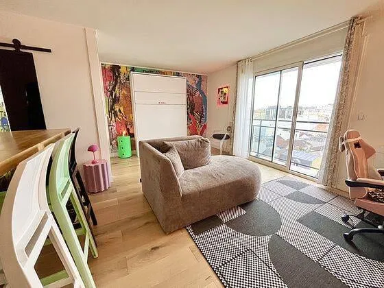 Pièce de vie avec fauteuil et grande fenêtre