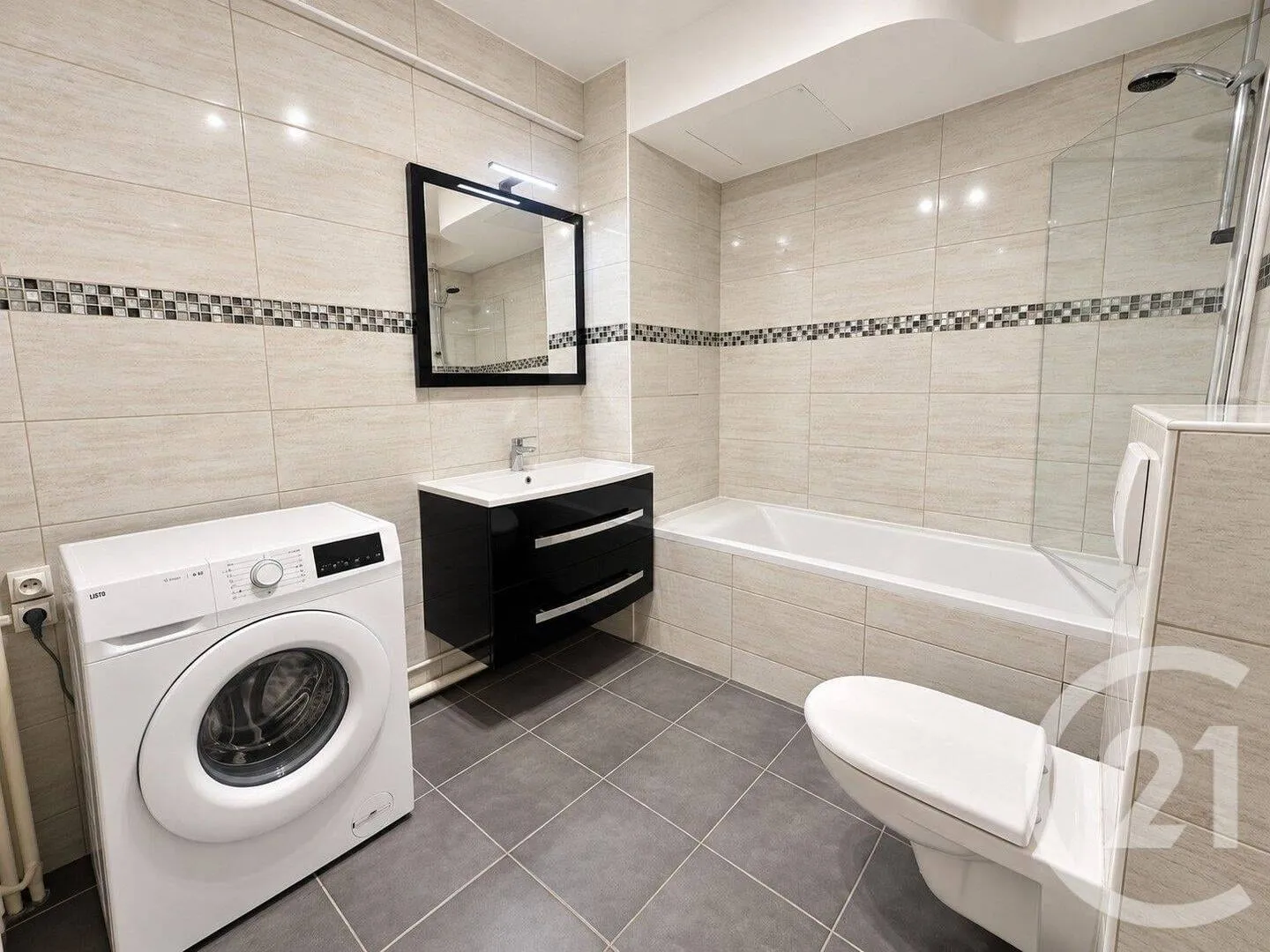 Salle de bains avec lave-linge et baignoire