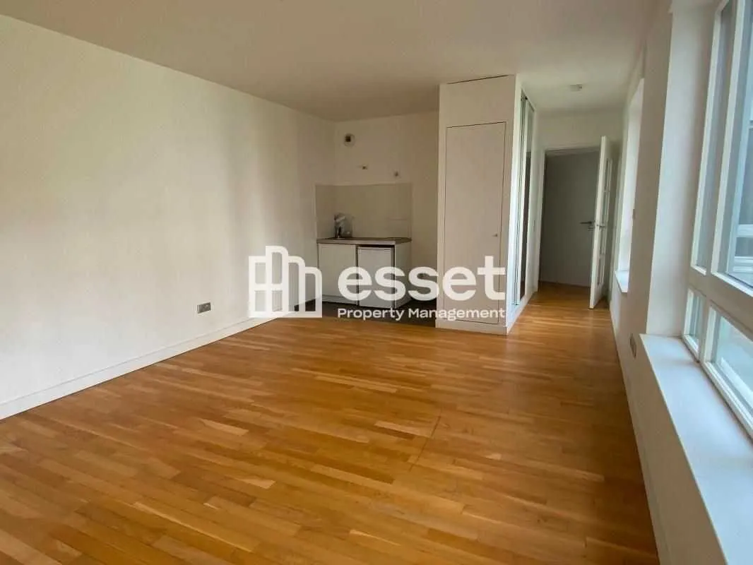 Pièce de vie avec parquet et grandes fenêtres